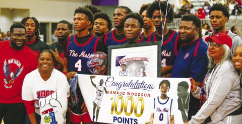 Putnam County senior Tamaud Woodson (center) celebrates with teammates and coaches during halftime of the Elite Eight game against Fitzgerald after reaching his 1,000th career point. LANCE MCCURLEY/Staff