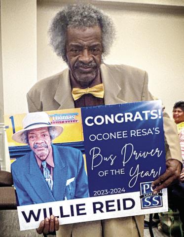 Willie Reid holds up the sign he received to honor his 56 years of service. CONTRIBTUED