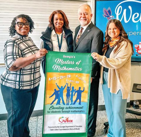 Putnam County Middle School eighth grade math teacher Crystal Watkins, Principal Monica Macklin, State Superintendent Richard Woods, and eighth grade math teacher Keeli Sanders show off the awarded banner. CONTRIBUTED