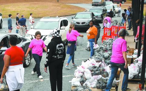 A steady stream of cars rolled through the parking lot of Eatonton’s old Putnam County Elementary School on Saturday morning as volunteers handed out thousands of pounds of food to grateful recipients. IAN TOCHER/Staff