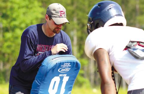 Beasley (left) coaches up a Putnam County player during blocking drills at practice this past spring. LANCE McCURLEY/Staff