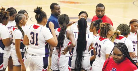 During a timeout, PCHS head coach Derrick Arrington (left) and assistant coach David Levester encourage the Lady Eagles to regroup.