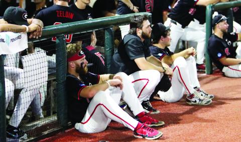 Georgia baseball players sit and watch as N.C. State players celebrate after winning 8-5 on Monday night to advance. LANCE McCURLEY/Staff
