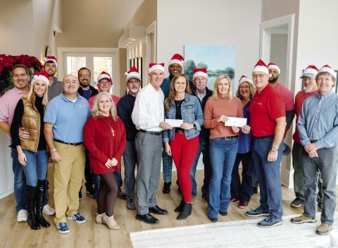 Luxury Lake Oconee’s Ted Baker (center, white shirt) and Weidmann Remodeling’s Dan Weidmann (right, red shirt) present Lake Oconee Area Builders Association’s Wendy Daniel and Christy Kimbrough, alongside team members from both offices, with donations to support LOABA’s Christmas Outreach Drive. CONTRIBUTED