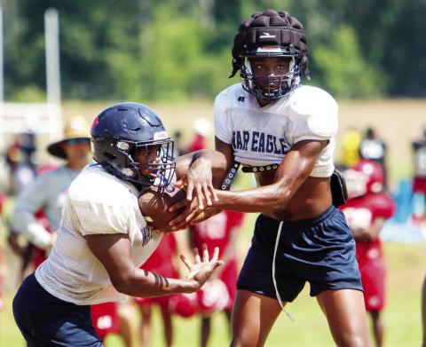 Putnam County senior quarterback Jamarion Robertson hands the ball off to sophomore running back Elijah Dunn during a scrimmage against Hawkinsville last week. (LANCE MCCURLEY/Staff)