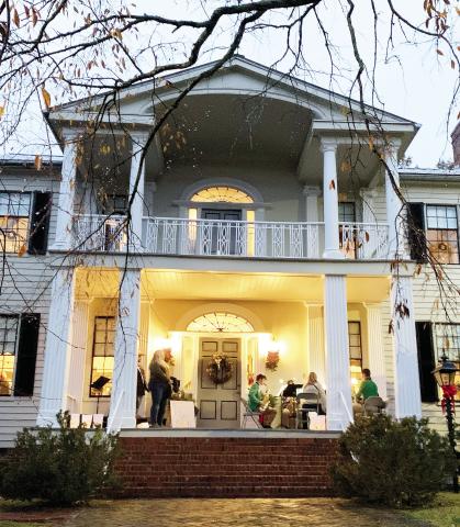 The Baldwin High School sax ensemble performed on the front porch of the historic home welcoming people in. Two attendees stopped to watch and hum along to the tunes of Christmas songs. BAILEY MCCULLY/Staff