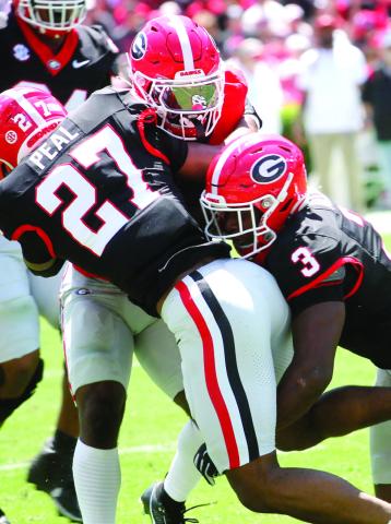 Georgia defender Chris Peal (27) and linebacker CJ Allen (3) bring down a ball carrier. BRAD HARRISON/Staff