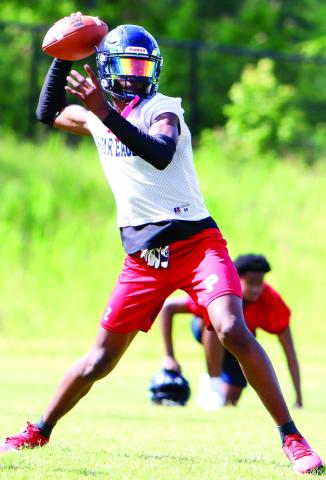Putnam County quarterback Jamarion Robertson drops back to pass during a practice in June. LANCE McCURLEY/Staff