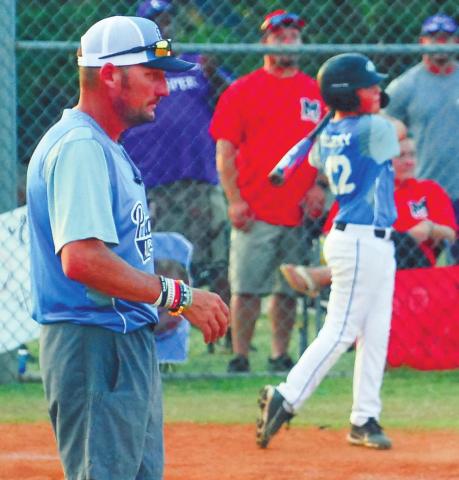 Putnam County head coach Grayson Huskins watches his team warm up, including Ethan Tillery (12).