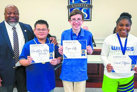 Superintendent Derick Austin presents certificates to students of the month (from left) Christopher Morales, Bryan Kelly and Larriah Pettigrew. CONTRIBUTED