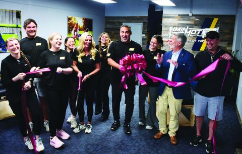 Greene County residents Dana and Dr. Pablo Santamaria (center, with scissors and bow) opened InMotion Wellness initially based on Pablo’s exposure to the benefits of targeted, assisted stretching after undergoing an operation to correct a painful back condition.