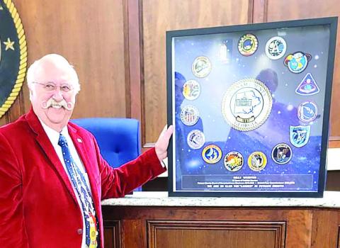 Billy Webster holds a framed montage of 13 shoulder patches from NASA’s Apollo program presented to him as a gift for his service as chairman. CONTRIBUTED