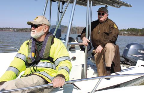 Putnam County Sheriff Howard Sills pilots a patrol boat Saturday, while Detective J.D. Turk closely watches the water on Lake Oconee in search of presumed drowned victim Gary Jones. CONTRIBUTED