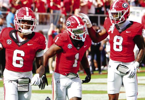 Georgia wide receiver Dominic Lovett (6), running back Trevor Etiennte (1) and wide receiver Colbie Young during Saturday’s win. LANCE McCURLEY/Staff