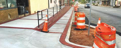 The sidewalk on North Jefferson that has been an embarrassing eyesore for two years looks complete except for the orange barrels, yellow tape and no landscaping. MARK ENGEL/Staff