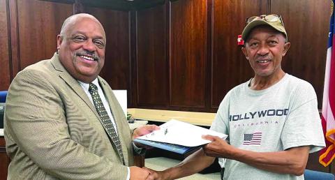 Kevin “Jack” Reid (right) of the Eatonton Streets Department received 10-years’ service recognition from Mayor John Reid. Afterward, Jack Reid told city council, “Y’all don’t know how much I appreciate working with y’all, working with the community … the best thing that ever happened to me was when I came to the city.” (IAN TOCHER/Staff)