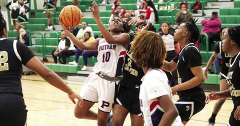Putnam County freshman Journey Waller (10) tries to go up for a contested layup over a Washington County defender last week. LANCE McCURLEY/Staff