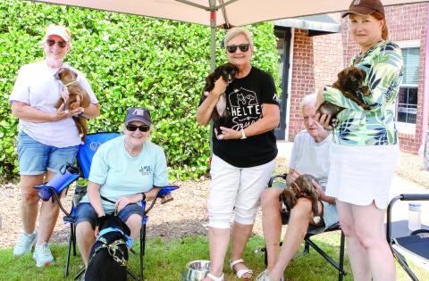 The volunteers of Lake Oconee Humane Society with 8-year-old Tripp and four of the puppies available for adoption. (LEIGH LOFREN/Staff)