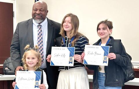 PCCSS Superintendent Derrick Austin (left) presented school bags and certificates to Putnam County students receiving Superintendent Student of the Month Awards for February (l-r): Catherine Wooten, Sophia Kelly, and Rivka Brown. ALIVIA BLANTON/Staff