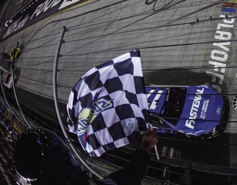 Chris Buescher, driver of the #17 Fastenal Ford, takes the checkered flag to win the Bass Pro Shop Night Race at Bristol Motor Speedway Saturday. (Logan Riely/Getty Images)