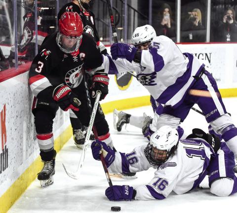Ice Dawgs captain Evan Parante (3) fights off a pair of Niagara defenders to chase down a puck behind the Purple Eagles’ net Saturday night at Akins Ford Arena in Athens. IAN TOCHER/Staff