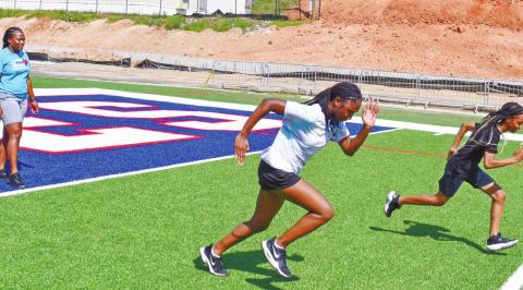 Bernicia Harris (left) and Alexis Evans race under Jakacha Nelson’s (far left) guidance. LENA HENSLEY/Staff