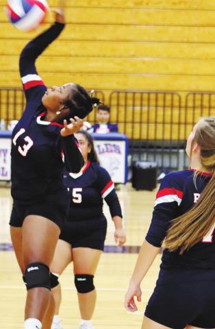 Senior Tytianna Little at the net with Lacey Bruce (7) and Angelica Alexander (15).