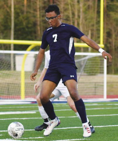 Putnam County junior midfielder Malcolm Marks (7) tries to dribble the ball away from a Lake Oconee Academy defender in a match against the Titans on April 1. TREY NORRIS/Staff