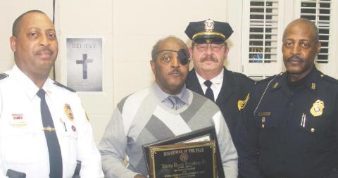 Eatonton Police officer Willie Brinkley Jr. holds two plaques he received – the MAC’s Employee of the Year award and he Eatonton Police Department Employee of the Year award – at a Mothers Against Crime annual holiday awards banquet in 2015. He is flanked by his brother, Leon Brinkley, a retired Georgia State University police officer, and his son, Willie Brinkley III, an Athens-Clarke County police officer. Behind them is then-Eatonton Police Chief Kent Lawrence. FILE PHOTO