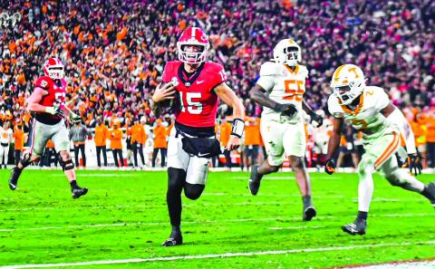 Georgia quarterback Carson Beck (15) races toward the end zone to score a touchdown. CHARLES JORDAN/Staff