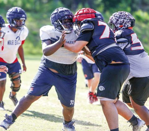 A Putnam County defensive lineman (72) goes up against an offensive lineman from Winder-Barrow during a padded camp held in Eatonton on July 17. LANCE McCURLEY/Staff