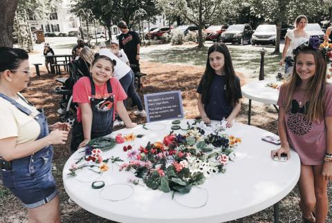Children enjoy making flower crowns at the May Day event. CONTRIBUTED