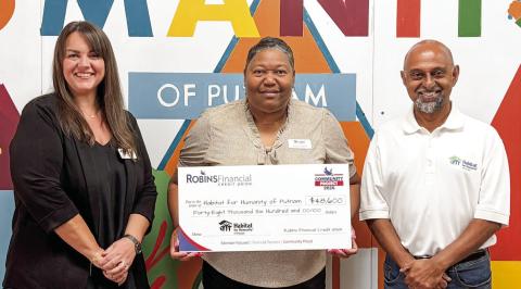Habitat for Humanity of Putnam Executive Director Murali Thirumal (right) accepts a $48,600 grant check from representatives of Robins Financial Credit Union. CONTRIBUTED