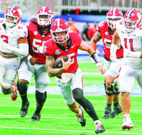 Georgia quarterback Carson Beck races past defenders for a first down. (LANCE McCURLEY/Staff)