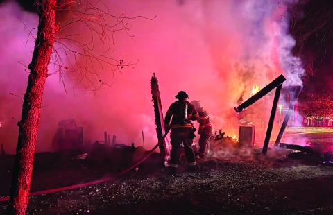 Putnam County Fire Department firefighters extinguish what was left of a fire that burned this detatched garage to the ground last week. CONTRIBUTED