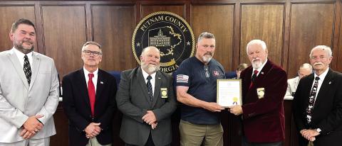 L-R: Newly elected District 1 Commissioner Tom McElhenney, District 2 Commissioner Daniel Brown, Commissioner Jeff Wooten of District 4, retiring Putnam County Fire Department Battalion Chief Michael Alford, County Chairman Bill Sharp, and District 3 Commissioner Dr. Steve Hersey stepped forward for Alford’s retirement recognition. IAN TOCHER/Staff