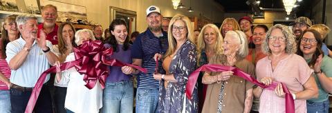 Surrounded by friends and family, Kirtsten Thompson (with scissors) officially opened her new store, Saving Grace, with a ribbon-cutting ceremony hosted last Saturday by the Eatonton-Putnam Chamber of Commerce. CONTRIBUTED