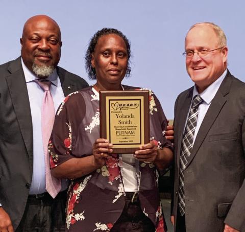 Superintendent Derick Austin (left) and Assistant Superintendent Scott Sauls present the HEART award to Yolanda Smith. BAILEY BALLARD/Staff