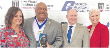 Eatonton Mayor John Reid (second from left) was all smiles after receiving high praise and recognition June 26, during the Georgia Municipal Association’s annual convention in Savannah. CONTRIBUTED