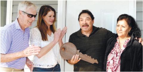 Putnam County Habitat for Humanity Board President Bucky Kahl and Jennifer Ishee, a member of the Habitat Family Selection Committee, present a ceremonial key Nov. 1, to new homeowners Alfredo and his wife, Gloria. IAN TOCHER/Staff