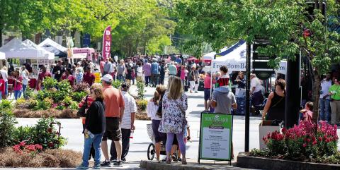 People walk the streets of downtown Greensboro while enjoying a previous, sunny Southland Jubilee. (CONTRIBUTED)