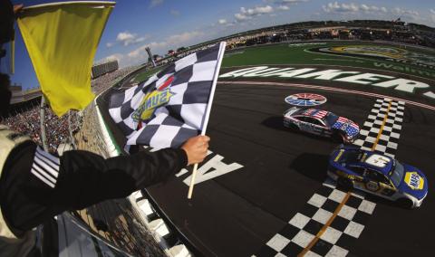 Chase Elliott, driver of the #9 NAPA Auto Parts Chevrolet, takes the checkered flag ahead of Ross Chastain, driver of the #1 Jockey Chevrolet, under caution to win the Cup Series Quaker State 400 at Atlanta Motor Speedway Sunday. (Jared C. Tilton photos/Getty Images)