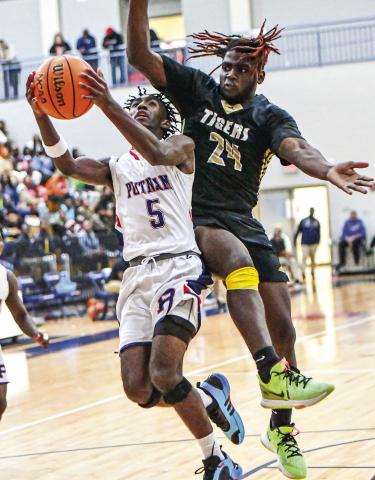 “Putnam County’s Jaylin Harper (5) goes up for a layup as Greene County’s RJ Monford (24) tries to block the shot. CHARLES JORDAN/Staff