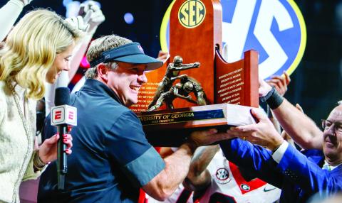 Georgia head coach Kirby Smart holds up the 2025 SEC Championship trophy after the Bulldogs knocked off Alabama 28-7 at Mercedes-Benz Stadium Dec. 6. LANCE MCCURLEY/Staff