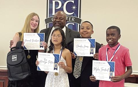 Putnam County School Superintendent Derick Austin recognizes the Student of the Month of each school, from left, Hannah Erickson (PC High School), Zoe Almanza Patino (PC Primary School), Charles Jones (PC Middle School), and Myles Treadwell (PC Elementary School). Each student was celebrated at Monday night’s board of education meeting and recognized along with their family members. LYNN HOBBS/Staff