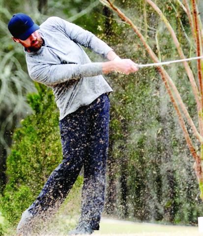 A golfer at the inaugural Project Putnam Golf Tourney hits a ball out of a sand trap at URGC in Eatonton. GORDON COLUMBINE/Staff