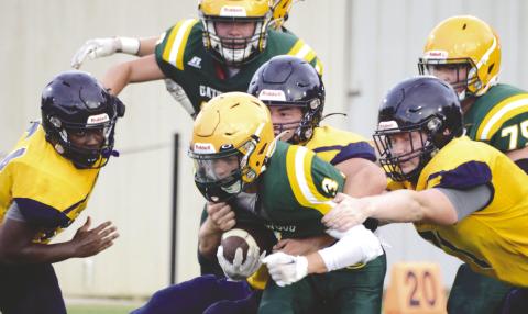 Junior running back Jackson Hewatt (3) is the center of attention of teammates and rivals alike in a first-quarter scrimmage run Friday night at Gatewood Schools in Eatonton, versus the Cavaliers of Mount de Sales Academy. IAN TOCHER/Staff