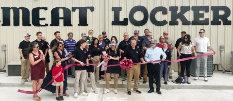 Lisa Simmons, co-owner of The Meat Locker with her husband Darin beside her, makes the official ribbon cut April 4 with Eatonton-Putnam Chamber of Commerce President Robbie King (in sunglasses) looking on. IAN TOCHER/Staff