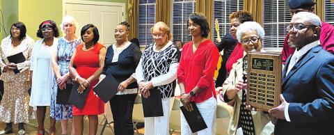 The Rev. Walter Milner presents Georgia Smith and the other members of Mothers Against Crime with the Christian Achievement Award. HANK SEGARS/Staff
