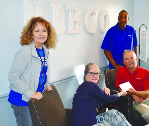 Plant manager at NIBCO Douglas Purnell (right seated) presents Festival Hall Director Nicole Chillemi (left seated) with a $500 sponsorship check. CONTRIBUTED